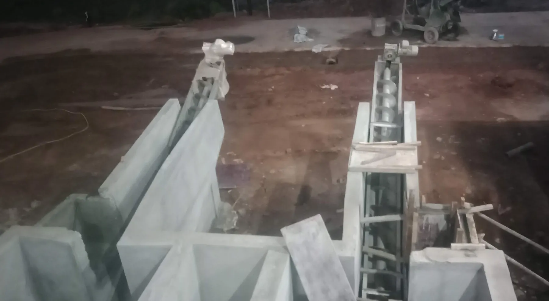 Inclined screw conveyor lifting grit out of the chamber